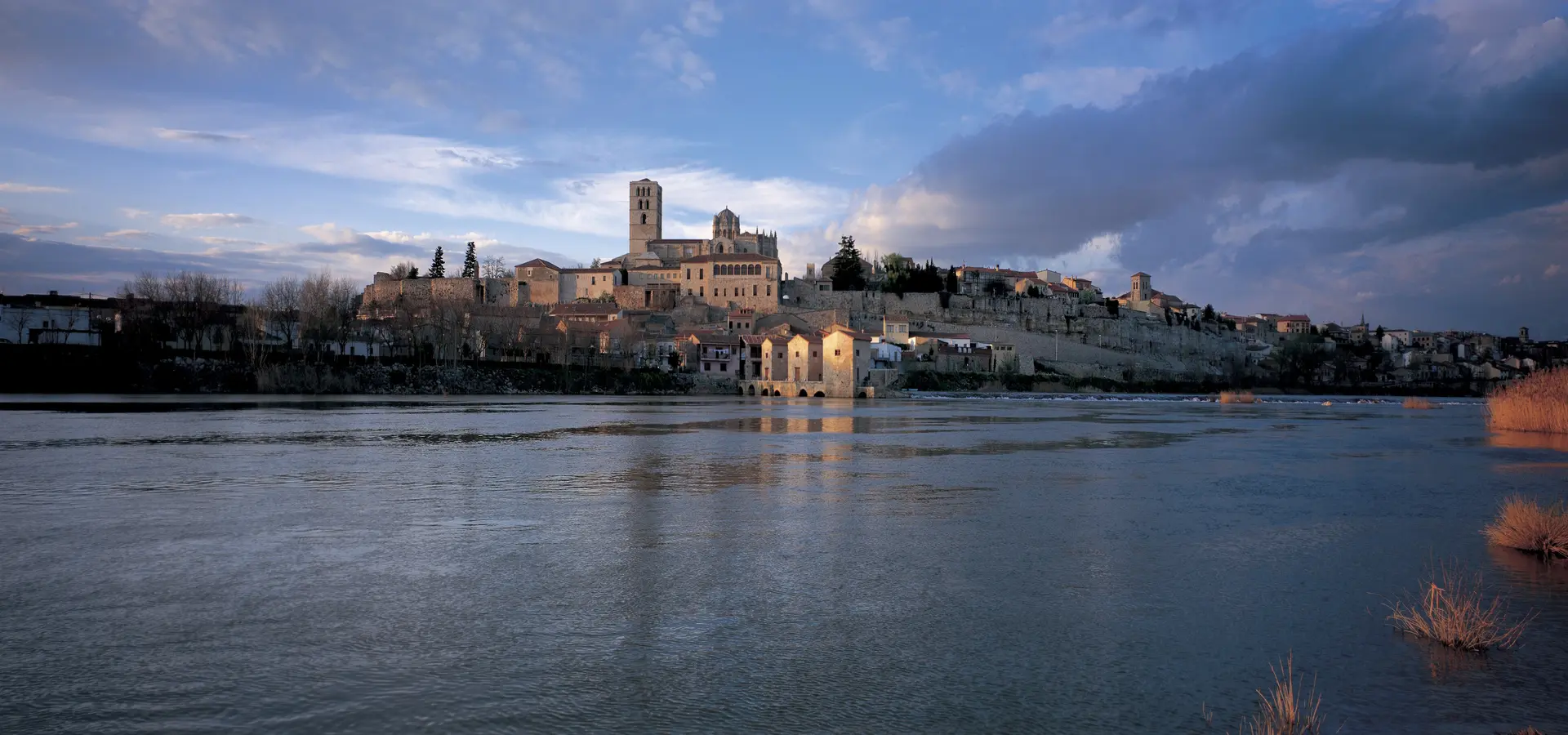 Panorámica horizontal de la ciudad histórica de Zamora, mostrando la Catedral de Zamora sobre el río Duero durante la hora dorada, cabecera de la firma Boutique Penal Pérez Oliva Abogados Penalistas.